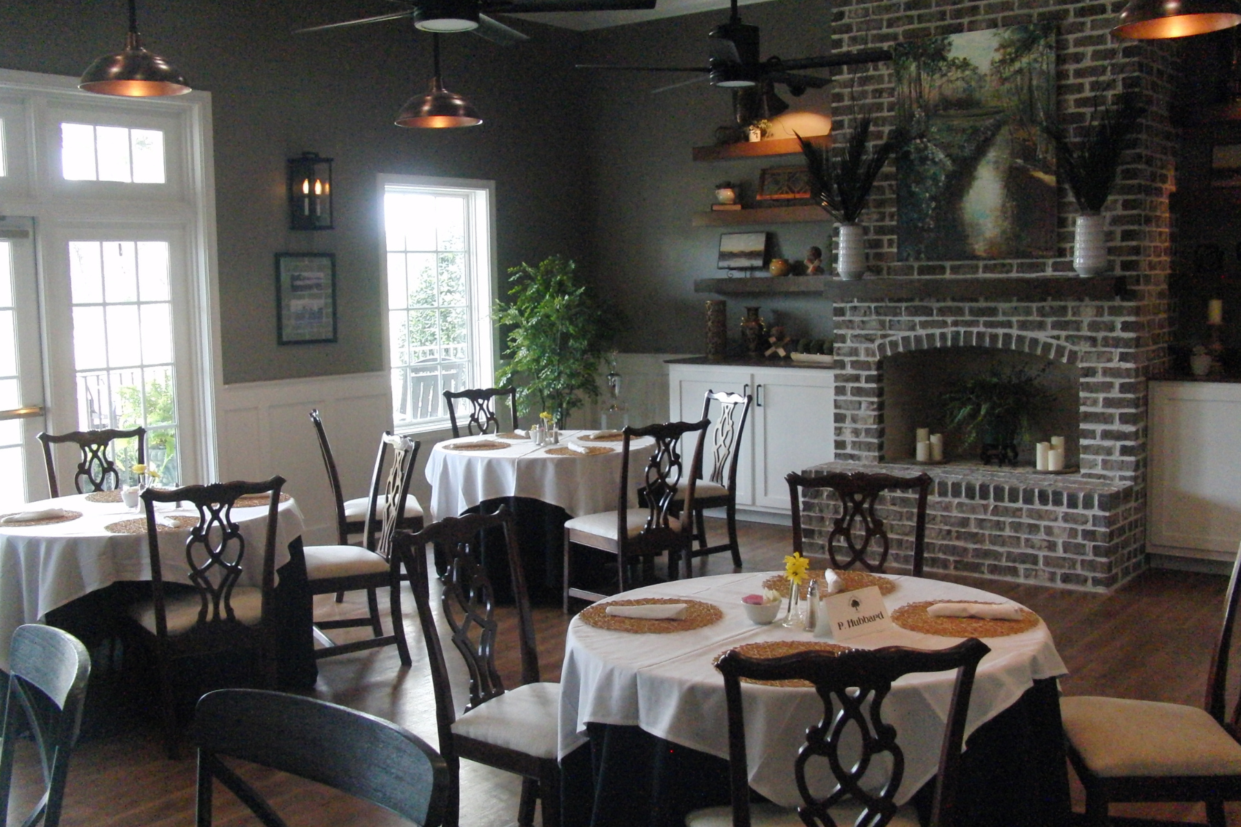The Black Creek Grill dining area with majestic furnishings and a brick fireplace at Darlington Country Club