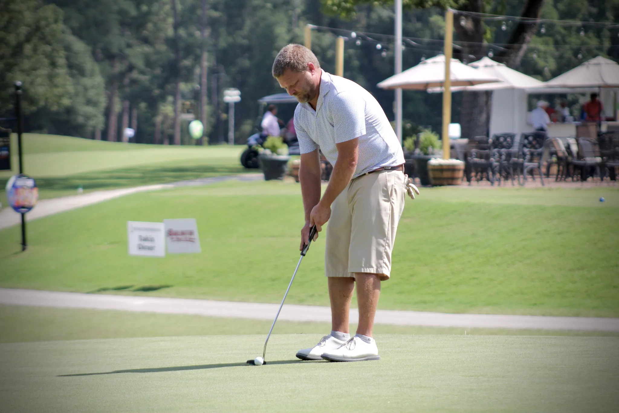 A golfer putting a golf ball on the green at Darlington Country Club