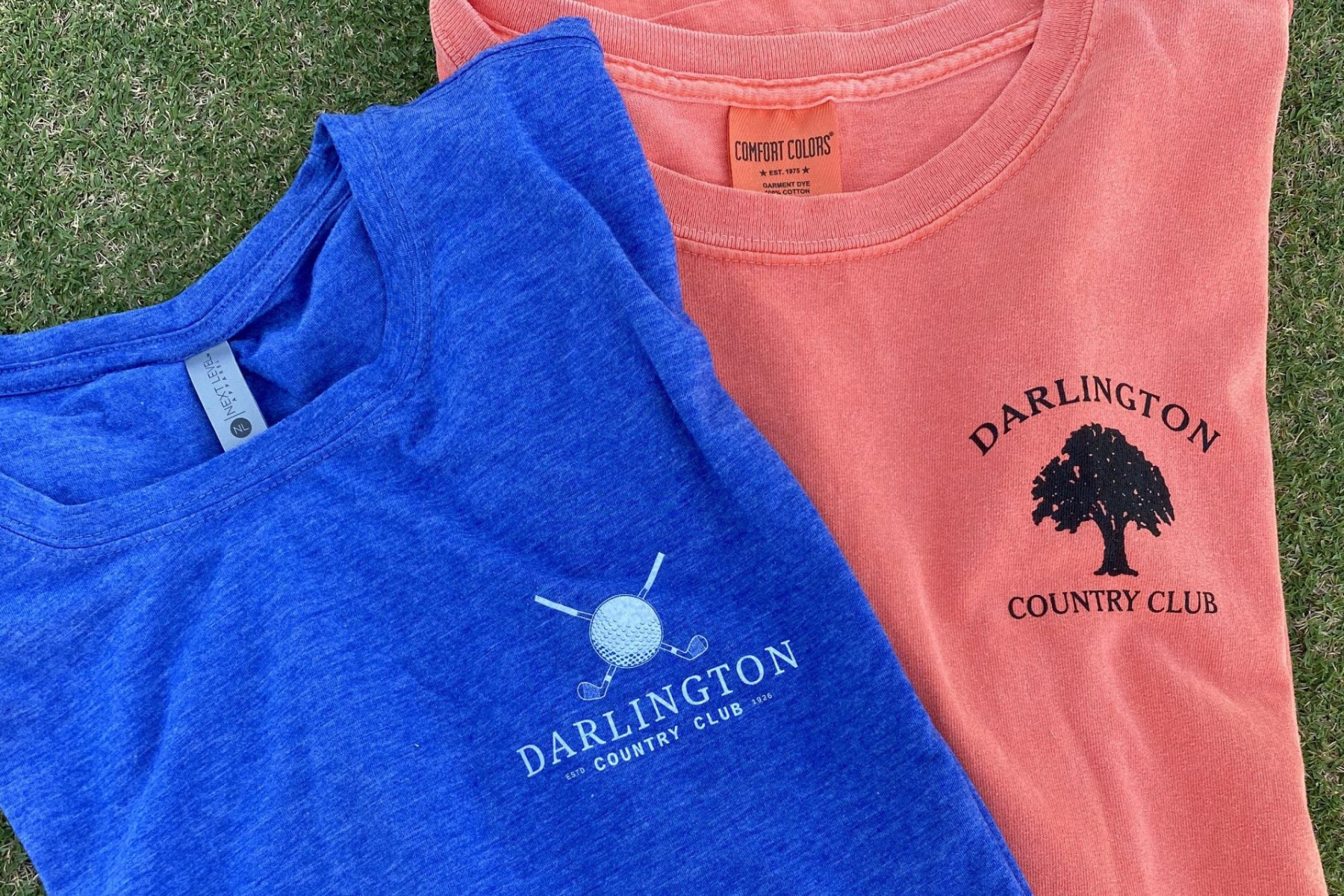 Darlington Country Club T-Shirts | Club Apparel A close up of Darlington Country Club t-shirts, one blue, one pink.
