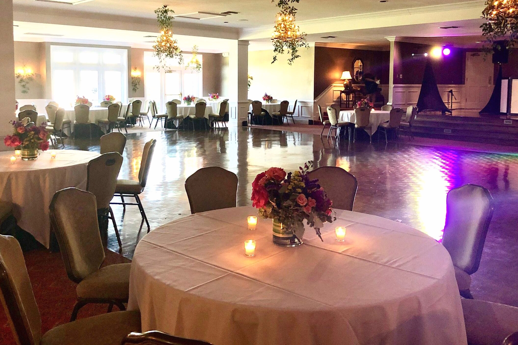 Unforgettable Events | Darlington Country Club's Beautiful Ballroom Ballroom with wooden flooring, dining tables, and hanging flora at Darlington Country Club