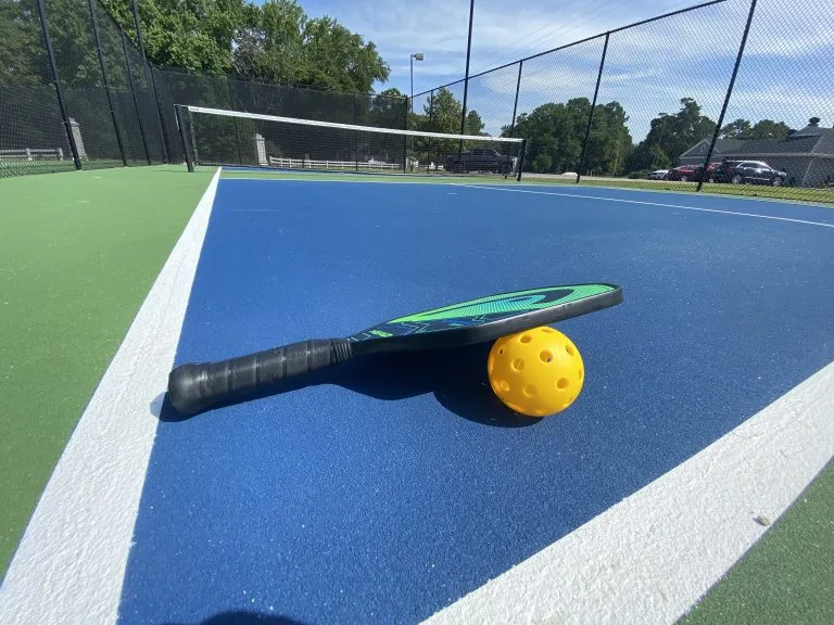 Close-up of a pickleball paddle and ball on the tennis courts at Darlington Country Club